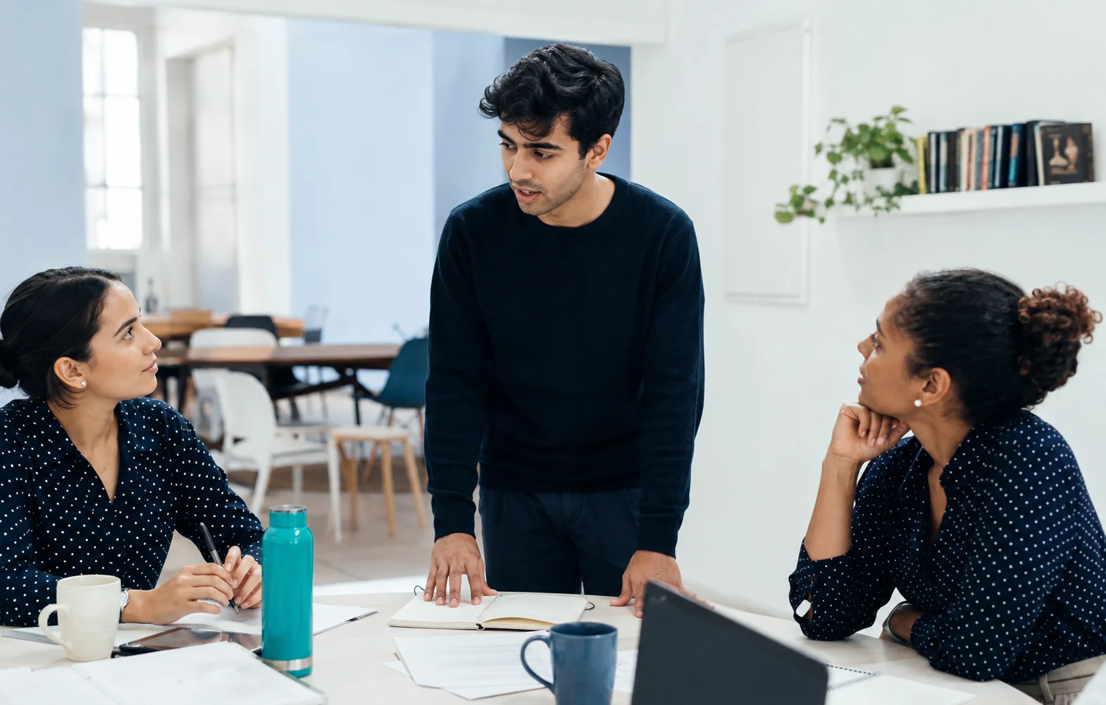 A man practicing speaking to two supportive colleagues